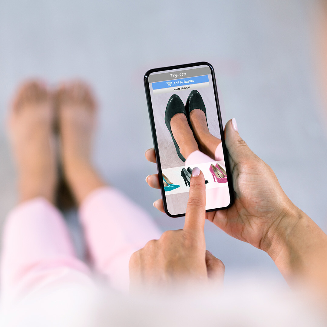 Woman Using Smartphone to Shop for Shoes Online, E-commerce Platform Showing Product Page.